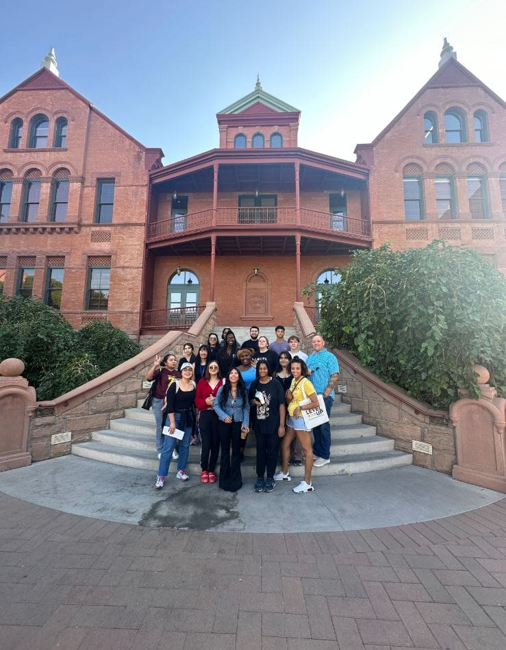 New Pathways for Youth participants and mentors gather outside a historic landmark during a youth leadership and college readiness field trip.