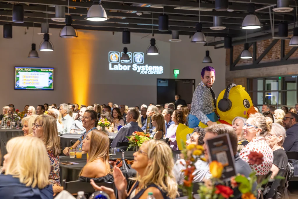 Attendees enjoying a nonprofit fundraising gala featuring entertainment, community engagement, and support for youth mentoring programs.