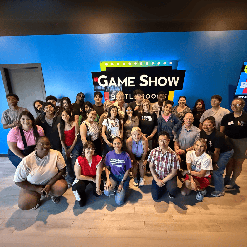 Students, mentors, and community members posing together at a Game Show Battle Rooms event