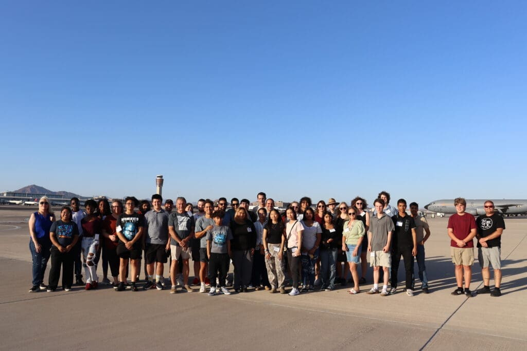 Large gathering of people assembled outdoors during daytime.