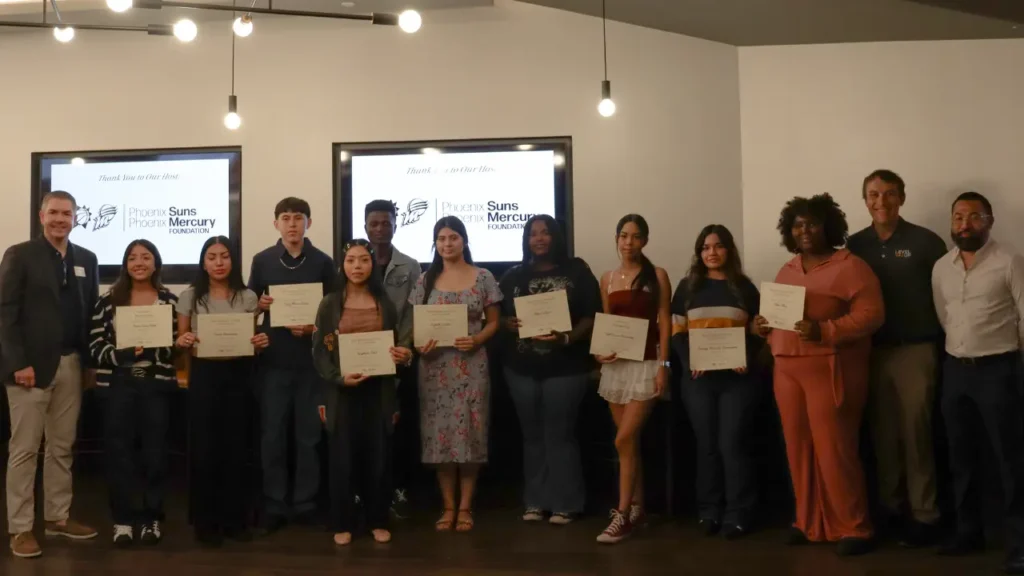A group of people standing together indoors at what appears to be an awards or recognition ceremony.